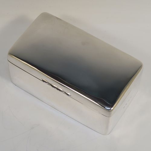 A very handsome Antique Edwardian Sterling Silver cigarette or cigar table box, having a plain rectangular body with nice rounded corners, a hinged lid having an applied thumb-piece, with a cedar wood-lined interior to the base and a removable divider. This elegant antique silver table box was made by A. and J. Zimmerman of Birmingham in 1903. The dimensions of this fine hand-made antique silver table cigar or cigarette box are length 17 cms (6.75 inches), depth 10 cms (4 inches), and height 7 cms (2.75 inches).