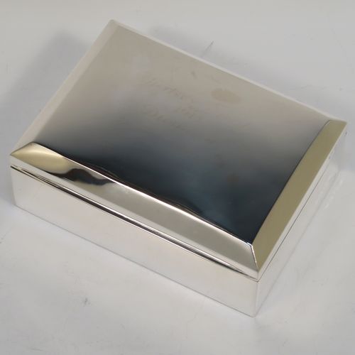 A very elegant Antique Sterling Silver cigarette / cigar table box, having a plain rectangular body, a hinged lid having an applied thumb-piece and chamfered edges, with a gold-gilt and cedar wood-lined interior to the base. This handsome antique silver table box was made by A. and J. Zimmerman of Birmingham in 1912. The dimensions of this fine hand-made antique silver table cigar or cigarette box are length 13.5 cms (5.3 inches), width 10 cms (4 inches), and height 5.5 cms (2.25 inches).