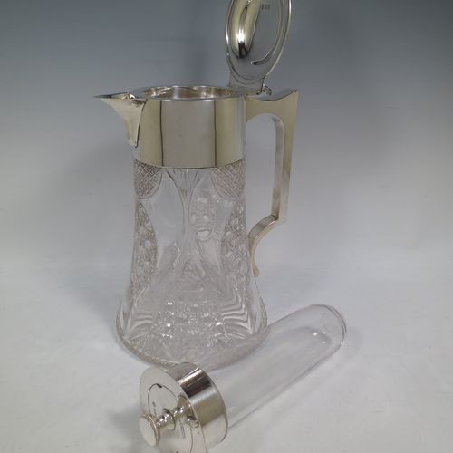 A very handsome and large Antique Victorian Sterling Silver and hand-cut crystal lemonade or pimms jug, having a plain round mount, a hinged lid with a pierced thumb-piece, a plain square cross-section handle, a sparrow-beak style spout, together with an original internal glass tube for crushed ice (with silver handle and bayonet-fit lift-off lid), a hand-cut crystal body with lobes of hobnail-cut decoration, and all sitting on a flat star-cut base. Made by Streeter and Co. Ltd., of London in 1899. The dimensions of this fine hand-made antique silver and crystal pimms or lemonade jug are height 28 cms (11 inches), length 21 cms (8.25 inches), and diameter at base 17 cms (6.75 inches).