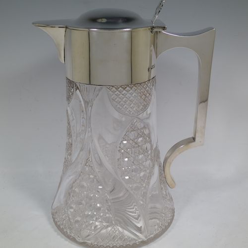 A very handsome and large Antique Victorian Sterling Silver and hand-cut crystal lemonade or pimms jug, having a plain round mount, a hinged lid with a pierced thumb-piece, a plain square cross-section handle, a sparrow-beak style spout, together with an original internal glass tube for crushed ice (with silver handle and bayonet-fit lift-off lid), a hand-cut crystal body with lobes of hobnail-cut decoration, and all sitting on a flat star-cut base. Made by Streeter and Co. Ltd., of London in 1899. The dimensions of this fine hand-made antique silver and crystal pimms or lemonade jug are height 28 cms (11 inches), length 21 cms (8.25 inches), and diameter at base 17 cms (6.75 inches).