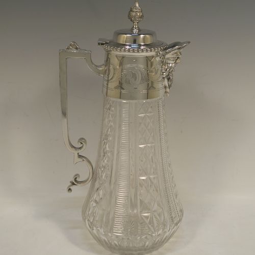 A very pretty Antique Victorian Silver Plated and hand-cut crystal claret jug, having a hand-engraved mount with scroll decoration, a Bacchus face on the spout, a hinged domed lid with a bead border and cast finial, a scrolled cast handle, a round hand-cut crystal body with tapering sides and a hobnail fluted panel pattern, all sitting on a flat star-cut base. Made by Mappin and Webb in there Princes Plate in ca. 1890. The dimensions of this fine hand-made antique silver-plated and crystal claret jug are height 28.5 cms (11.25 inches), length 14 cms (5.5 inches), and diameter at base is 11.5 cms (4.5 inches)..  
