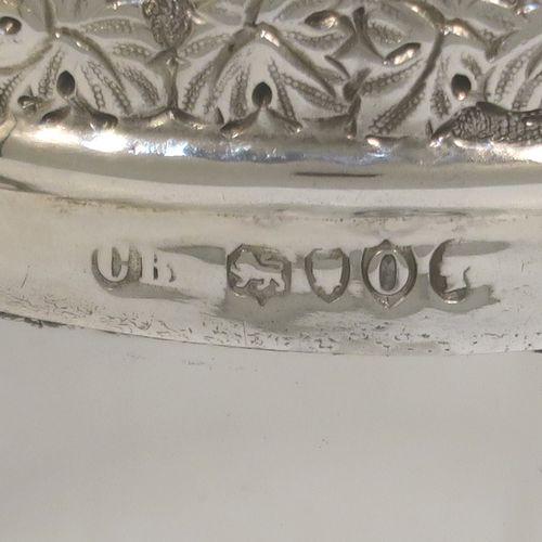 A very handsome Antique Victorian Sterling Silver and hand-cut crystal claret jug, having an ornate Bacchus style round mount with hand-chased grapevine work, a tendril style sided handle with a security ring, a hinged lid with a cast rampant lion and shield finial, together with a hand-cut crystal round body with straight sides and a tucked under belly above a flat star-cut base. This beautiful antique silver claret jug was made by Charles Boyton of London in 1889. The dimensions of this fine hand-made antique silver and crystal claret jug are height 27 cms (10.5 inches), and length 18.5 cms (7.5 inches).