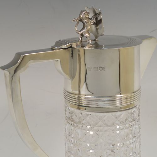 A very handsome Antique Sterling Silver and hand-cut crystal claret jug, having a plain round mount and spout with reeded borders, a plain square cross-section scroll handle attached to a security ring, a flat hinged lid with a cast rampant lion and shield finial, together with a hand-cut hobnail pattern crystal round body with straight sides and flared bottom above a flat star-cut base. This beautiful antique silver claret jug was made by Charles Boyton of London in 1912. The dimensions of this fine hand-made antique silver and crystal claret jug are height 26 cms (10.25 inches), and length 17 cms (6.75 inches).