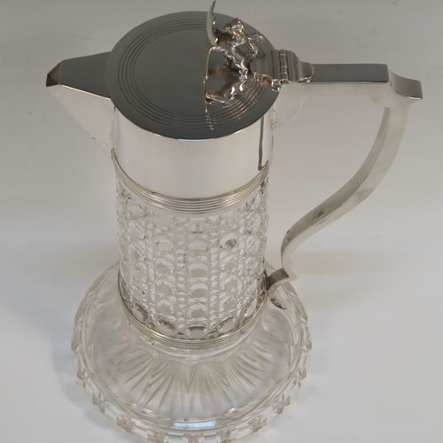 A very handsome Antique Sterling Silver and hand-cut crystal claret jug, having a plain round mount and spout with reeded borders, a plain square cross-section scroll handle attached to a security ring, a flat hinged lid with a cast rampant lion and shield finial, together with a hand-cut hobnail pattern crystal round body with straight sides and flared bottom above a flat star-cut base. This beautiful antique silver claret jug was made by Charles Boyton of London in 1912. The dimensions of this fine hand-made antique silver and crystal claret jug are height 26 cms (10.25 inches), and length 17 cms (6.75 inches).