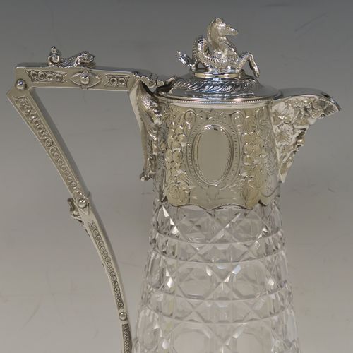 A very pretty Antique Victorian Silver Plated and hand-cut crystal claret jug, having a hand-chased mount with floral decoration and Bacchus face on the spout, a cast Pegasus finial, a scrolled cast handle, and a crystal body with hobnail cut. This beautiful antique silver-plated claret jug was made in ca. 1880. The dimensions of this fine hand-made silver-plated claret jug are height 29 cms (11.5 inches), length 16 cms (6.3 inches).