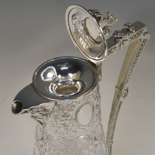 A very pretty Antique Victorian Silver Plated and hand-cut crystal claret jug, having a hand-chased mount with floral decoration and Bacchus face on the spout, a cast Pegasus finial, a scrolled cast handle, and a crystal body with hobnail cut. This beautiful antique silver-plated claret jug was made in ca. 1880. The dimensions of this fine hand-made silver-plated claret jug are height 29 cms (11.5 inches), length 16 cms (6.3 inches).