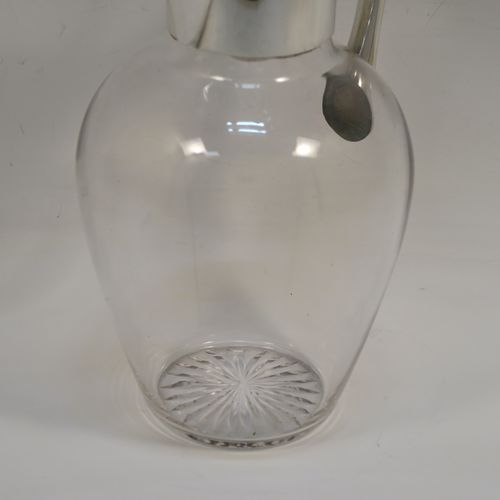 A handsome Antique Victorian Sterling Silver and hand-cut crystal claret jug, having a plain round mount, with a flat hinged lid, a plain angular handle, and a cut-off sparrow-beak style spout, together with a hand-cut crystal body sitting on a star-cut flat base. This elegant antique silver and crystal claret jug was made by Heath and Middleton of London in 1898. The dimensions of this fine hand-made antique silver and crystal claret jug are height 19.5 cms (7.75 inches), and length 13 cms (5 inches).