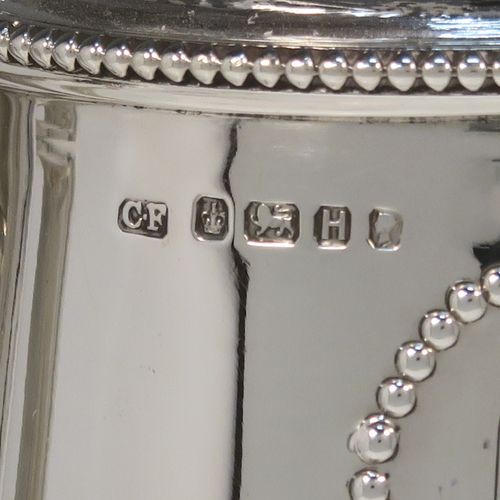 A very elegant Antique Victorian Sterling Silver and hand-cut crystal claret jug, having a plain round mount with applied bead-edged borders, a plain square cross-section side handle, a hinged stepped lid with a cast round finial, together with a hand-cut crystal round body with straight tapering sides and a tucked under belly above a pedestal foot. This handsome silver and crystal claret jug was made by Charles Favell of Sheffield in 1875. The dimensions of this fine hand-made antique silver and crystal claret jug are height 28 cms (11 inches), and length 13.5 cms (5.25 inches). Please note that this item has two oval cartouches with bead borders one of which is engraved with a part crest.