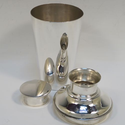A very handsome Sterling Silver Art Deco cocktail shaker, having a plain round body with tapering sides, with a pull-off lid and interior strainer section, and a bead edge to the main body and lid. This elegant silver cocktail shaker was made by Synyer and Beddoes of Birmingham in 1939. The dimensions of this fine hand-made silver cocktail shaker are height 19 cms (7.5 inches), diameter at widest point 9.5 cms (3.75 inches), and it weighs approx. 329g (10.6 troy ounces).