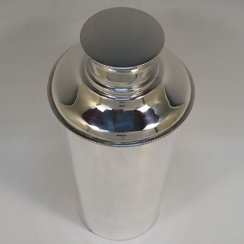 A very handsome Sterling Silver Art Deco cocktail shaker, having a plain round body with tapering sides, with a pull-off lid and interior strainer section, and a bead edge to the main body and lid. This elegant silver cocktail shaker was made by Synyer and Beddoes of Birmingham in 1939. The dimensions of this fine hand-made silver cocktail shaker are height 19 cms (7.5 inches), diameter at widest point 9.5 cms (3.75 inches), and it weighs approx. 329g (10.6 troy ounces).