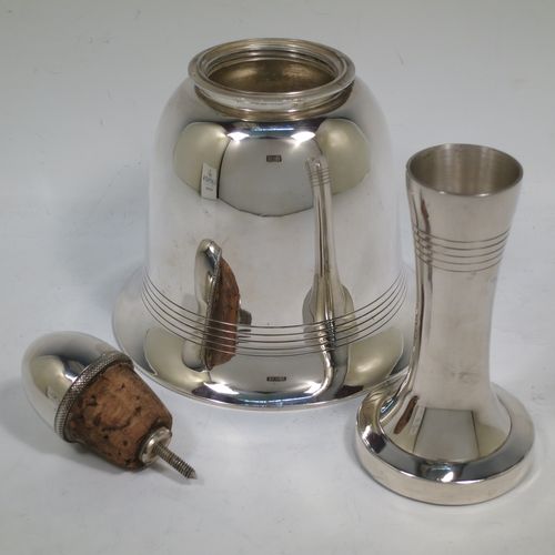 A very unusual novelty Silver-Plated cocktail shaker in the shape of a table bell, having a plain round body with hand-engraved reeded decoration, with a screw-off hollow handle attached to the main body, and a screw-off terminal lid with cork seal covering a pouring strainer section. Made by Edward and Sons of Glasgow, Scotland, in ca. 1930. The dimensions of this fine hand-made silver plated table bell cocktail shaker are height 28 cms (11 inches), diameter at base 15 cms (6 inches).