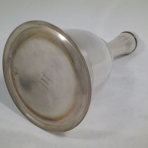 A very unusual novelty Silver-Plated cocktail shaker in the shape of a table bell, having a plain round body with hand-engraved reeded decoration, with a screw-off hollow handle attached to the main body, and a screw-off terminal lid with cork seal covering a pouring strainer section. Made by Edward and Sons of Glasgow, Scotland, in ca. 1930. The dimensions of this fine hand-made silver plated table bell cocktail shaker are height 28 cms (11 inches), diameter at base 15 cms (6 inches).