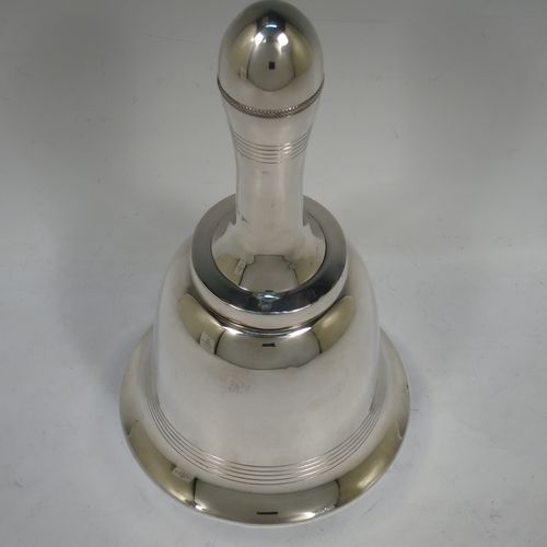 A very unusual novelty Silver-Plated cocktail shaker in the shape of a table bell, having a plain round body with hand-engraved reeded decoration, with a screw-off hollow handle attached to the main body, and a screw-off terminal lid with cork seal covering a pouring strainer section. Made by Edward and Sons of Glasgow, Scotland, in ca. 1930. The dimensions of this fine hand-made silver plated table bell cocktail shaker are height 28 cms (11 inches), diameter at base 15 cms (6 inches).