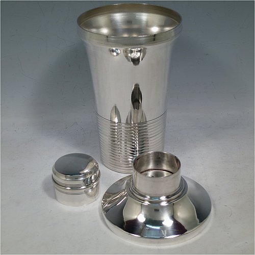 A very handsome Art Deco style Silver-Plated cocktail shaker, having a plain round body with tapering sides, with a pull-off lid and a strainer section, together with a lower band of hand-chased reeded decoration. Made in ca. 1930. The dimensions of this fine hand-made silver plated cocktail shaker are height 21 cms (8.25 inches), diameter at widest point 10 cms (4 inches).