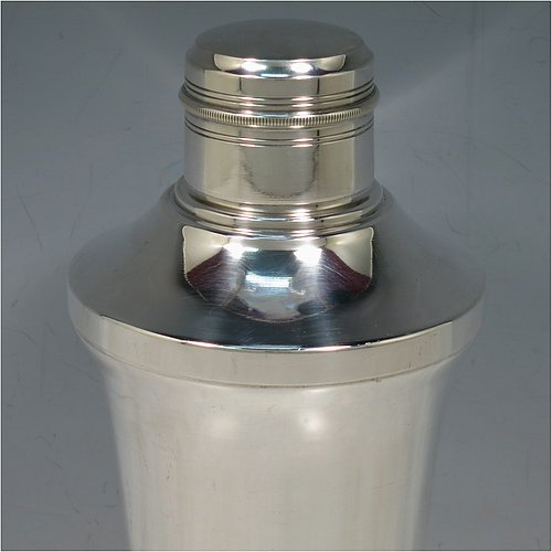A very handsome Art Deco style Silver-Plated cocktail shaker, having a plain round body with tapering sides, with a pull-off lid and a strainer section, together with a lower band of hand-chased reeded decoration. Made in ca. 1930. The dimensions of this fine hand-made silver plated cocktail shaker are height 21 cms (8.25 inches), diameter at widest point 10 cms (4 inches).