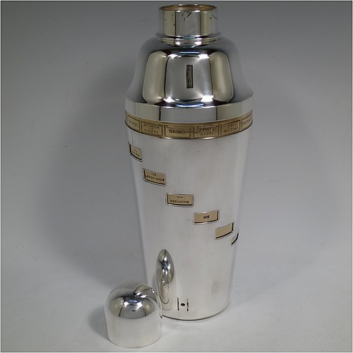A rare and unusual Silver-Plated Art Deco mechanical menu cocktail shaker, having a plain round body with tapering sides, with a pull-off lid and strainer section, with an internal revolving gold-plated menu system showing various cocktails on the upper menu and then all the required constituents in small staggered windows down the body. Made in ca. 1930. The dimensions of this fine hand-made silver plated menu cocktail shaker are height 27 cms (10.75 inches), diameter at widest point 10 cms (4 inches).
