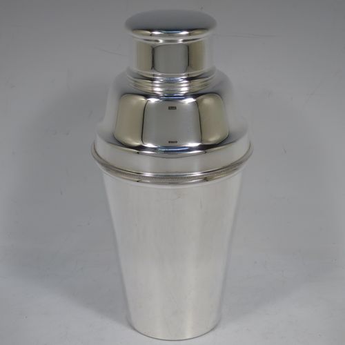 A handsome Silver-Plated Art Deco cocktail shaker, having a plain round body with tapering sides, with a pull-off lid, and strainer section with an applied knurled edge, and the main body with a flat base. Made in Sheffield, England, in ca. 1930. The dimensions of this fine hand-made silver plated cocktail shaker are height 19 cms (7.5 inches), diameter at widest point 9 cms (3.5 inches).    
