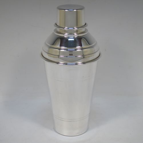 A very stylish Silver-Plated Art Deco cocktail shaker, having a plain round body with tapering sides and hand-chased bands of reeded decoration, a plain round and flat top pull-off lid, and a central removable strainer section. Made in ca. 1930 in Sheffield, England. The dimensions of this fine hand-made silver plated cocktail shaker are height 20 cms (8 inches), and diameter at widest point is 9 cms (3.5 inches).  
