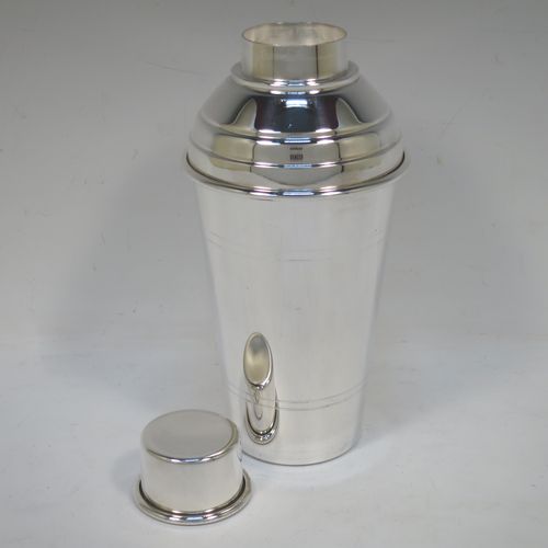 A very stylish Silver-Plated Art Deco cocktail shaker, having a plain round body with tapering sides and hand-chased bands of reeded decoration, a plain round and flat top pull-off lid, and a central removable strainer section. Made in ca. 1930 in Sheffield, England. The dimensions of this fine hand-made silver plated cocktail shaker are height 20 cms (8 inches), and diameter at widest point is 9 cms (3.5 inches).  