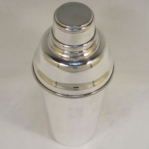 A very handsome Sterling Silver Art Deco cocktail shaker, having a plain round body with tapering sides, with a pull-off lid and interior strainer section, and an applied knurled edge to the main body. This elegant silver cocktail shaker was made by J. C. Vickery of Birmingham in 1929. The dimensions of this fine hand-made silver cocktail shaker are height 20 cms (8 inches), diameter at widest point 9 cms (3.5 inches), and it weighs approx. 340g (11 troy ounces).  