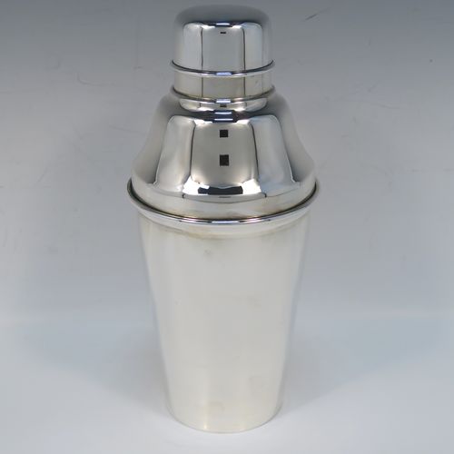 A very stylish Silver-Plated Art Deco cocktail shaker, having a plain round body with tapering sides, a plain round and flat top pull-off lid, and a central removable strainer section. This elegant silver-plated cocktail shaker was made in ca. 1930 in Sheffield, England. The dimensions of this fine hand-made silver-plated cocktail shaker are height 24 cms (9.5 inches), and diameter at widest point is 10 cms (4 inches).  