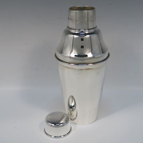 A very stylish Silver-Plated Art Deco cocktail shaker, having a plain round body with tapering sides, a plain round and flat top pull-off lid, and a central removable strainer section. This elegant silver-plated cocktail shaker was made in ca. 1930 in Sheffield, England. The dimensions of this fine hand-made silver-plated cocktail shaker are height 24 cms (9.5 inches), and diameter at widest point is 10 cms (4 inches).  