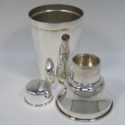 A very stylish Silver-Plated Art Deco cocktail shaker, having a plain round body with tapering sides, a plain round and flat top pull-off lid, and a central removable strainer section. This elegant silver-plated cocktail shaker was made in ca. 1930 in Sheffield, England. The dimensions of this fine hand-made silver-plated cocktail shaker are height 24 cms (9.5 inches), and diameter at widest point is 10 cms (4 inches).  