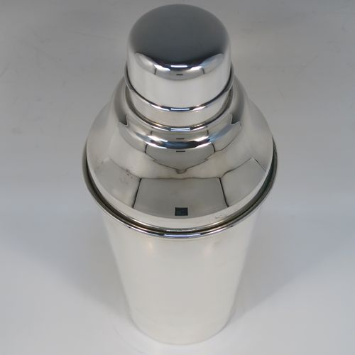 A very stylish Silver-Plated Art Deco cocktail shaker, having a plain round body with tapering sides, a plain round and flat top pull-off lid, and a central removable strainer section. This elegant silver-plated cocktail shaker was made in ca. 1930 in Sheffield, England. The dimensions of this fine hand-made silver-plated cocktail shaker are height 24 cms (9.5 inches), and diameter at widest point is 10 cms (4 inches).  