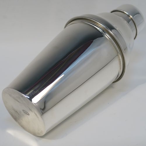 A very stylish Silver-Plated Art Deco cocktail shaker, having a plain round body with tapering sides, a plain round and flat top pull-off lid, and a central removable strainer section. This elegant silver-plated cocktail shaker was made in ca. 1930 in Sheffield, England. The dimensions of this fine hand-made silver-plated cocktail shaker are height 24 cms (9.5 inches), and diameter at widest point is 10 cms (4 inches).  