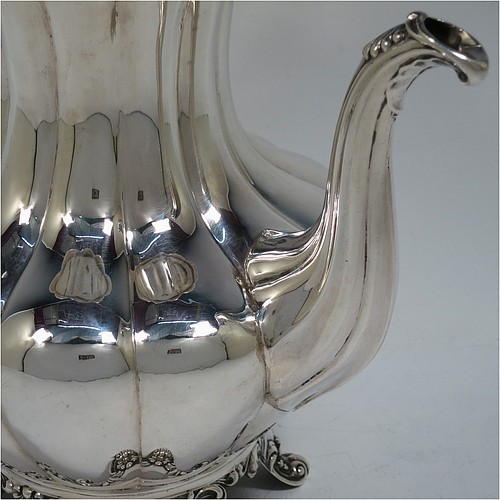 A very handsome Antique Victorian Sterling Silver hand-chased coffee pot, having a round hand-chased baluster body with melon-style fluting, a hinged lid with melon fluting and original cast floral finial, an insulated silver handle, a fluted spout, and all sitting on four shell and scroll feet. Made by the Savoury Brothers of London in 1846. The dimensions of this fine hand-made antique silver coffee pot are height 26 cms (10.25 inches), length 26 cms (10.25 inches), and it weighs approx. 862g (28 troy ounces).