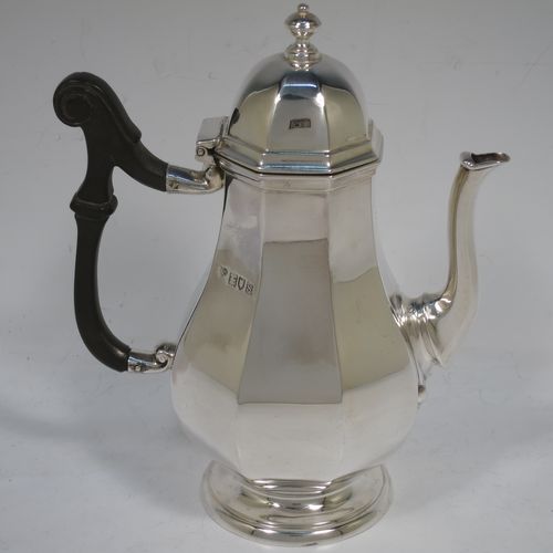 A handsome Antique Sterling Silver small coffee pot for two people, having a plain panelled and bellied body, with a black wooden scroll handle, a hinged and panelled domed lid with cast finial, and all sitting on a pedestal feet. Made by the Goldsmiths & Silversmiths of London in 1913. The dimensions of this fine hand-made antique sterling silver small coffee pot are height 17 cms (6.75 inches), length 14.5 cms (5.75 inches), and it weighs approx. 250g (8 troy ounces).    