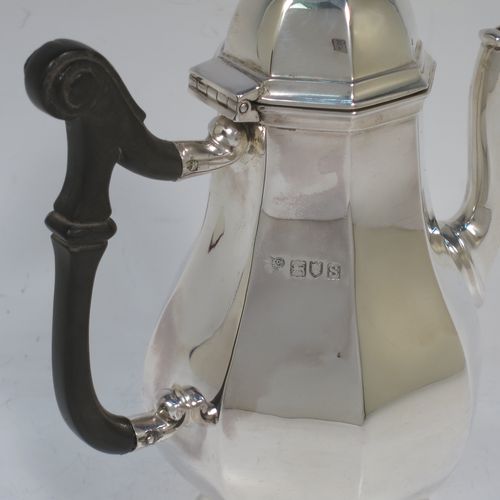 A handsome Antique Sterling Silver small coffee pot for two people, having a plain panelled and bellied body, with a black wooden scroll handle, a hinged and panelled domed lid with cast finial, and all sitting on a pedestal feet. Made by the Goldsmiths & Silversmiths of London in 1913. The dimensions of this fine hand-made antique sterling silver small coffee pot are height 17 cms (6.75 inches), length 14.5 cms (5.75 inches), and it weighs approx. 250g (8 troy ounces).