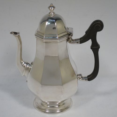 A handsome Antique Sterling Silver small coffee pot for two people, having a plain panelled and bellied body, with a black wooden scroll handle, a hinged and panelled domed lid with cast finial, and all sitting on a pedestal feet. Made by the Goldsmiths & Silversmiths of London in 1913. The dimensions of this fine hand-made antique sterling silver small coffee pot are height 17 cms (6.75 inches), length 14.5 cms (5.75 inches), and it weighs approx. 250g (8 troy ounces).