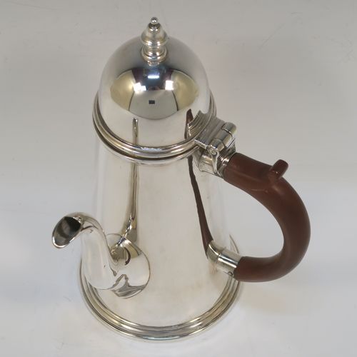 A very handsome Antique Sterling Silver George I style side-handled coffee pot, having a plain round body with straight tapering sides, a hinged domed lid with cast urn-shaped finial, a curved spout, a hand-carved brown-stained wooden scroll handle, and all sitting on a collet foot. This elegant silver coffee-pot was made by P and F of Sheffield in 1917. The dimensions of this fine hand-made antique silver side-handled coffee pot are length 12.5 cms (5 inches), height 21.5 cms (8.5 inches), and it weighs approx. 465g (15 troy ounces).