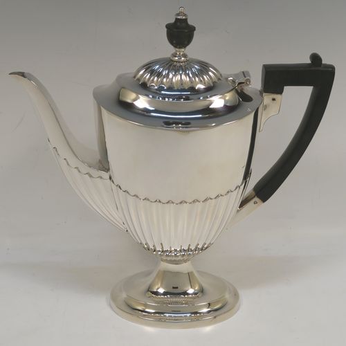 A pretty Antique Victorian Sterling Silver coffee pot, in a Queen Anne style, having an oval tapering body with hand-chased half-fluted decoration, a black wooden handle, a hinged lid with an invisible flat hinge and wooden finial, and all sitting on a pedestal foot. This beautiful antique silver coffee pot was made by Charles Stuart Harris of London in 1899. The dimensions of this fine hand-made antique silver coffee pot are length 22.5 cms (8.75 inches), height 23.5 cms (9.25 inches), and it weighs approx. 450g (14.5 troy ounces)   