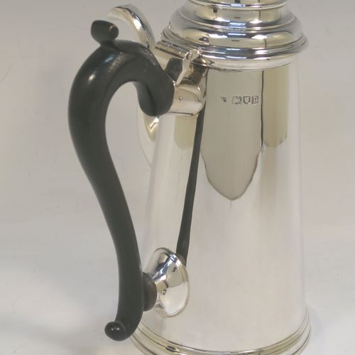 A large and very handsome Antique Edwardian Sterling Silver George II style side-handled coffee pot, having a plain round body with straight tapering sides, a hinged domed lid with cast urn-shaped finial, a curved and panelled spout, a hand-carved wooden scroll handle, and all sitting on a flat base. This elegant silver coffee-pot was made by D. and J. Welby of London in 1910. The dimensions of this fine hand-made antique silver side-handled coffee pot are length 13.5 cms (5.25 inches), height 23.5 cms (9.25 inches), and it weighs approx. 750g (24 troy ounces).