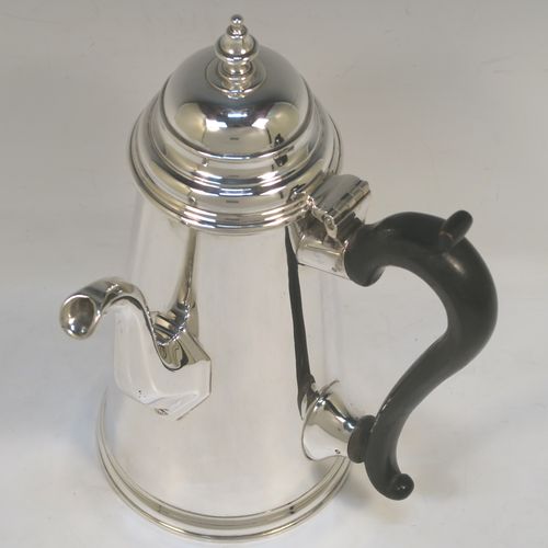 A large and very handsome Antique Edwardian Sterling Silver George II style side-handled coffee pot, having a plain round body with straight tapering sides, a hinged domed lid with cast urn-shaped finial, a curved and panelled spout, a hand-carved wooden scroll handle, and all sitting on a flat base. This elegant silver coffee-pot was made by D. and J. Welby of London in 1910. The dimensions of this fine hand-made antique silver side-handled coffee pot are length 13.5 cms (5.25 inches), height 23.5 cms (9.25 inches), and it weighs approx. 750g (24 troy ounces).