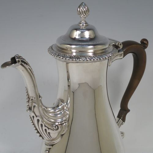 A very handsome Antique Georgian Sterling Silver coffee pot, having a plain round bellied body, with applied gadroon borders, a wooden scroll handle, a flame knop finial, and anthemion leaf decorated spout. Made by William Grundy London in 1775. The dimensions of this fine hand-made antique silver coffee pot are height 26 cms (10.25 inches), length 22 cms (8.75 inches), and it weighs approx. 800g (25.8 troy ounces).    