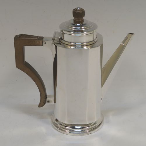 A very elegant Art Deco style Sterling Silver bachelor size coffee pot, having a straight-sided panelled body, a brown wooden side-handle with stepped thumb-piece, a stepped hinged lid with wooden finial, a straight panelled spout, and all sitting on a collet foot. This beautiful silver Art Deco coffee pot was made by Charles S. Green & Co. Ltd., of Birmingham in 1933. This Art Deco coffee pot would be suitable for serving two people and the dimensions of this fine hand-made silver coffee pot are length 16 cms (6.25 inches), height 16.5 cms (6.5 inches), and it weighs approx. 280g (9 troy ounces).  