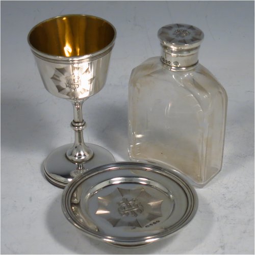 An Antique Victorian sterling silver three-piece travelling communion set consisting of chalice, paten, and wine bottle. The chalice having a round body with reeded borders, a gold-gilt interior, and sitting on a pedestal foot. The paten having a round body with a reeded border, and sitting on a collet foot. The wine bottle having a plain round screw-off lid, an original glass stopper, and the glass body with hand-cut panelled decoration. All three are engraved with a Christogram, and all sit in their original blue velvet-lined presentation box. Made by Charles Rawlings & William Summers of London in 1860. The dimensions of this fine hand-made silver travelling communion set are height of chalice 8 cms (3.25 inches), diameter of paten 6.8 cms (2.6 inches), and with a total weight of approx. 82g (2.6 troy ounces).    