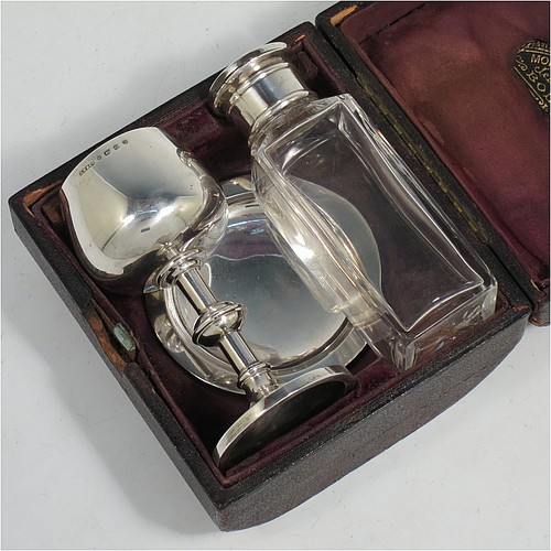 An Antique Victorian Sterling Silver three-piece travelling communion set consisting of chalice, paten, and wine bottle. The chalice having a plain round body with a middle baluster stem, and sitting on a pedestal foot. The paten having a plain round body with a flat border, and sitting on a pedestal foot. The wine bottle having a plain round screw-off corked lid, and the glass body with hand-cut panelled decoration. All three pieces sit in their original purple satin and velvet-lined presentation box. Made by Horace Woodward and Co., of Birmingham in 1882. The dimensions of this fine hand-made antique silver travelling communion set are height of chalice 9 cms (3.5 inches), diameter of paten 7 cms (2.75 inches), height of bottle 10 cms (4 inches), and with a total weight of approx. 93g (3 troy ounces). Please note that the interior material lining is stained, there is damage to the wooden box where the clasp is, and there is a contemporaneous inscription underneath the paten.