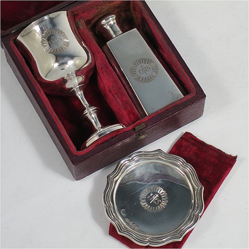 An Antique early Victorian Sterling Silver three-piece travelling communion set consisting of chalice, paten, and wine bottle. The chalice having a plain round bellied body, a gold-gilt interior, and sitting on a pedestal foot. The paten having a round body with an applied reeded and shaped border, and sitting on a collet foot. The wine bottle having a plain rectangular body with cut-corners and round screw-off lid, with a crystal stopper. All three pieces are hand-engraved with a Christogram, and they are all sitting in their original maroon velvet-lined presentation box. Made by John Evans II of London in 1844. The dimensions of this fine hand-made antique silver travelling communion set are height of chalice 9 cms (3.5 inches), diameter of paten 6.5 cms (2.5 inches), length of bottle 8cms (3.25 inches), and with a total weight of approx. 131g (4.2 troy ounces).