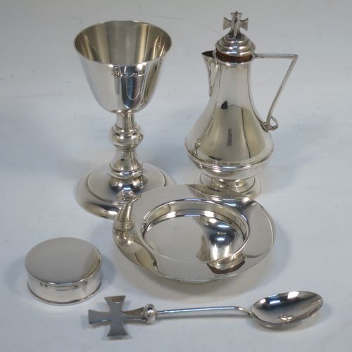 A Sterling Silver five-piece travelling communion set consisting of chalice, paten, anointing spoon, wine bottle, and pyx box. The chalice having a plain round body, and sitting on a pedestal foot. The paten having a plain round body, and sitting on a collet foot. The wine bottle having a plain round body with pull-off lid, and a cork seal. The anointing spoon having a plain oval bowl and cruciform finial. The pyx box having a plain round body with pull-off lid. All sitting in their original dark blue satin and velvet-lined presentation box. Made by Elkington and Co., of Birmingham in 1934. The dimensions of this fine hand-made silver travelling communion set are height of chalice 9.5 cms (3.75 inches), diameter of paten 8 cms (3.25 inches), length of spoon 11 cms (4.25 inches), and with a total weight of approx. 214g (6.9 troy ounces).