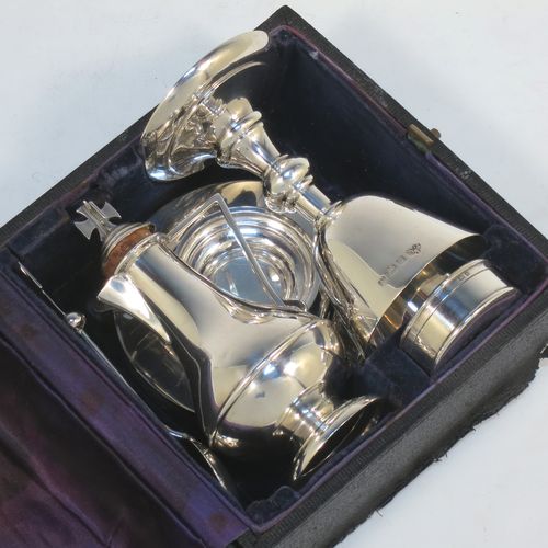 A Sterling Silver five-piece travelling communion set consisting of chalice, paten, anointing spoon, wine bottle, and pyx box. The chalice having a plain round body, and sitting on a pedestal foot. The paten having a plain round body, and sitting on a collet foot. The wine bottle having a plain round body with pull-off lid, and a cork seal. The anointing spoon having a plain oval bowl and cruciform finial. The pyx box having a plain round body with pull-off lid. All sitting in their original dark blue satin and velvet-lined presentation box. Made by Elkington and Co., of Birmingham in 1934. The dimensions of this fine hand-made silver travelling communion set are height of chalice 9.5 cms (3.75 inches), diameter of paten 8 cms (3.25 inches), length of spoon 11 cms (4.25 inches), and with a total weight of approx. 214g (6.9 troy ounces).