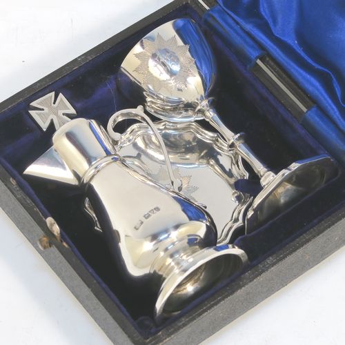 A very elegant Antique Edwardian Sterling Silver three-piece travelling communion set consisting of chalice, paten, and wine ewer. The chalice having a plain round bellied body, a gold-gilt interior, and sitting on a pedestal foot. The paten having a round body with an applied Chippendale border, and sitting on a pedestal foot. The wine ewer having a plain bellied body, a pull-off top with cork stopper and cruciform finial, a scroll side-handle, and sitting on a pedestal foot. All three pieces are hand-engraved with an IHS Christogram, and they are all sitting in their original dark blue satin and velvet-lined presentation box. This beautiful communion service was made by Charles Cook of Chester in 1905. The dimensions of this fine hand-made antique silver travelling communion set are height of chalice 8.5 cms (3.3 inches), diameter of paten 7 cms (2.75 inches), height of wine ewer 11 cms (4.25 inches), and with a total weight of approx. 160g (5.2 troy ounces). Please note that the paten has a contemporaneous presentation inscription underneath-to be removed.