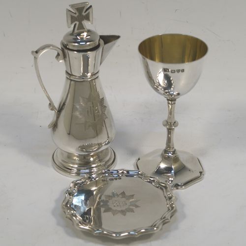 A very elegant Antique Edwardian Sterling Silver three-piece travelling communion set consisting of chalice, paten, and wine ewer. The chalice having a plain round bellied body, a gold-gilt interior, and sitting on a pedestal foot. The paten having a round body with an applied Chippendale border, and sitting on a pedestal foot. The wine ewer having a plain bellied body, a pull-off top with cork stopper and cruciform finial, a scroll side-handle, and sitting on a pedestal foot. All three pieces are hand-engraved with an IHS Christogram, and they are all sitting in their original dark blue satin and velvet-lined presentation box. This beautiful communion service was made by Charles Cook of Chester in 1905. The dimensions of this fine hand-made antique silver travelling communion set are height of chalice 8.5 cms (3.3 inches), diameter of paten 7 cms (2.75 inches), height of wine ewer 11 cms (4.25 inches), and with a total weight of approx. 160g (5.2 troy ounces). Please note that the paten has a contemporaneous presentation inscription underneath-to be removed.