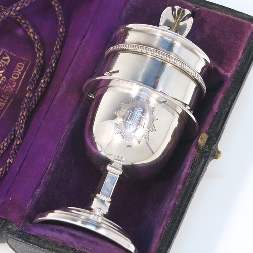 A handsome and unusual Sterling Silver two-piece travelling communion set consisting of a chalice body for consecrated wine, together with a bayonet fit lift-off pyx box with cover lid for host wafers. The lid with an applied cross-shaped finial, and the chalice and pyx body having gold-gilt interiors, all in its original purple velvet and satin-lined carrying case. This elegant silver communion set was made by Mowbray and Co., of London in 1939. The dimensions of this fine hand-made silver travelling communion set are height 11 cms (4.25 inches), diameter of main body 5 cms (2 inches), and it weighs approx. 154g (5 troy ounces). Please note that the main body is engraved with a Christogram.