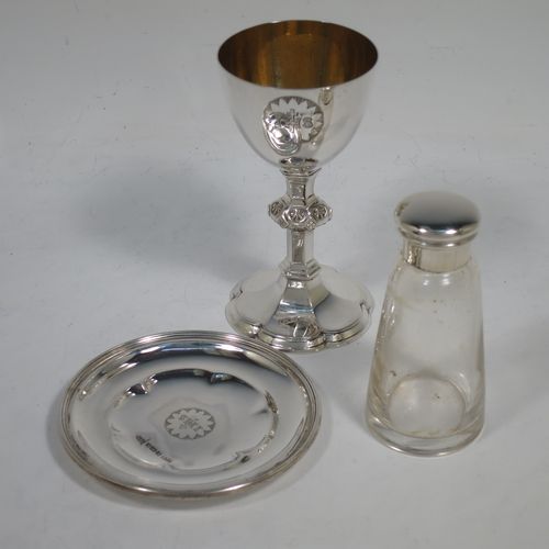 An Antique Victorian Sterling Silver three-piece travelling communion set consisting of a chalice, paten, and wine bottle. The chalice having a plain round cup with a gold-gilt interior, a hand-chased middle baluster stem, and sitting on a spreading hexafoil pedestal foot. The paten having a plain round body with a hexafoil shaped interior and applied reeded border. The wine bottle having a plain round screw-off corked lid, and the glass body with tapering sides and flat base. All three pieces sit in their original dark blue velvet-lined presentation box. Made by Walker and Hall of Sheffield in 1892. The dimensions of this fine hand-made antique silver travelling communion set are height of chalice 10 cms (4 inches), diameter of paten 8.5 cms (3.3 inches), height of bottle 8 cms (3 inches), and with a total weight of approx. 125g (4 troy ounces).   