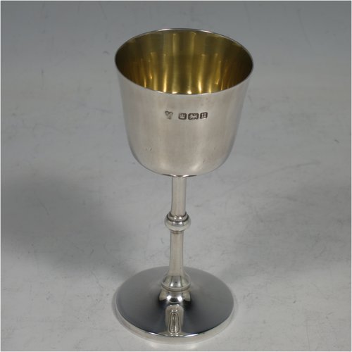 An Antique Sterling Silver four-piece travelling communion set consisting of chalice, paten, wine flagon, and pyx box. In a very plain round style, having a gold-gilt interior to the chalice, a pull-off lid with cork on the flagon, and a pull-off lid for the pyx box. All the pieces sit in their original blue velvet-lined presentation box which has an applied inscription attached to the top of the lid. Made by Martin Hall & Co., of Sheffield in 1912. The dimensions of this fine hand-made antique silver travelling communion set are height of flagon 13 cms (5 inches), diameter of paten 9 cms (3.5 inches), and with a total weight of approx. 254g (8.2 troy ounces).   