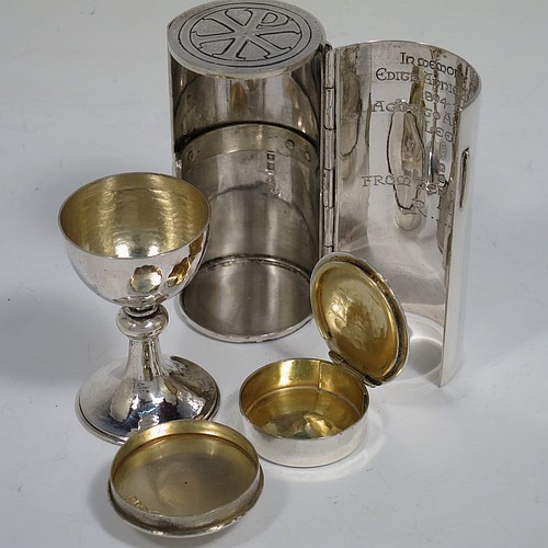 A lovely Arts and Crafts style Sterling Silver travelling communion set with hand-hammered decoration, consisting of a chalice with pull-off lid and gold-gilt interior, the lid also acting as a paten, a pyx box with hinged lid and gold-gilt interior, all fitted into an original silver cannister style hinged holder with a push-button latch and an applied Christogram on top. Made by Greenwood and Watts of London in 1927. The dimensions of this fine hand-made silver travelling communion set are length of cannister 8.5 cms (3.25 inches), height of chalice with lid 6.5 cms (2.5 inches), diameter of pyx box 3.5 cms (1.3 inches), with a total weight of approx. 212g (6.8 troy ounces). Please note that this item has an In Memorium inscription engraved on the inside of the cannister.